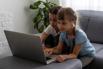 Cute children doing homework with laptop