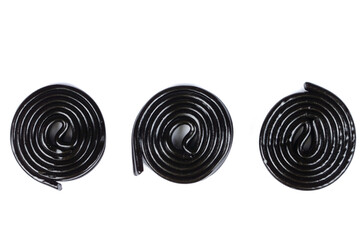 Black liquorice candies on a white background.