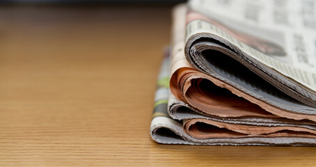 A stack of daily national newspapers on a desk