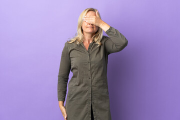Middle age Lithuanian woman isolated on purple background covering eyes by hands. Do not want to see something