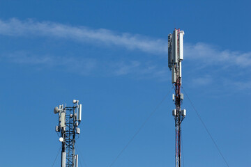 Mobile cell phone tower against the background of a blue sky and white cloud. Telecommunication TV...
