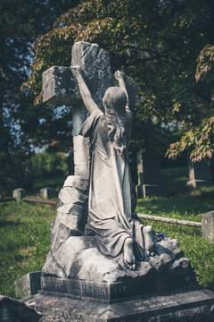 statue of praying woman hanging on tombstone