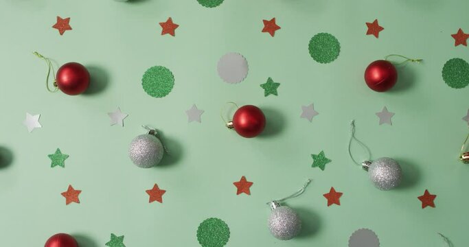 Christmas decorations with silver and red baubles on green background