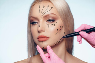 Beautiful blonde woman with markings for plastic surgery on her face