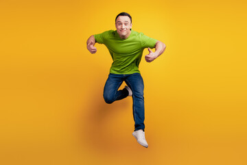 Fototapeta na wymiar Portrait of crazy energetic guy jump sport concept on yellow wall