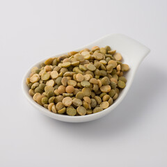 white dish spoon full of green lentils
