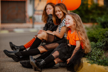 Sisters in halloween costumes like witches posing and having fun on the street.