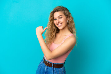 Young blonde woman isolated on blue background proud and self-satisfied