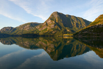 Efecto espejo en el fiordo con las montañas noruegas en el fondo