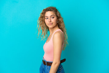 Young blonde woman isolated on blue background . Portrait