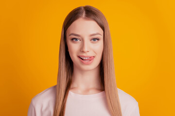 Fototapeta premium Portrait of flirty playful cute lady look camera stick out tongue on yellow background