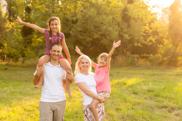 Fototapeta premium Happy family walking in field and looking at sunset