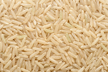 food background of uncooked long brown rice, top view