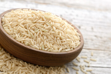 closeup of uncooked long brown rice on the wooden table