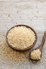 closeup of uncooked long brown rice on the wooden table