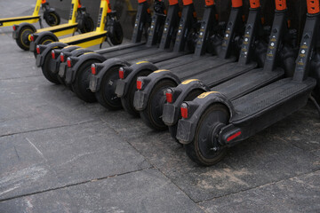 Several black electric scooters parked in a row, for rent. eco-friendly transport without pollution air.