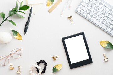 Digital tablet ebook mockup on elegant feminine office desk table. Flat lay top view women's workspace.