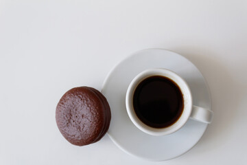 Delicious, hot coffee in a white mug on a saucer with chocolate tender cookies. Daily breakfast for one person. Top view