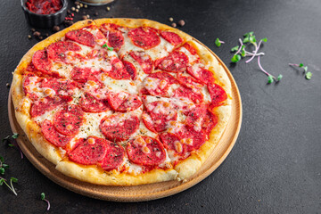 Pizza salami or pepperoni sausage, cheese, tomato sauce, dough fresh portion ready to eat meal snack on the table copy space food background rustic. top view