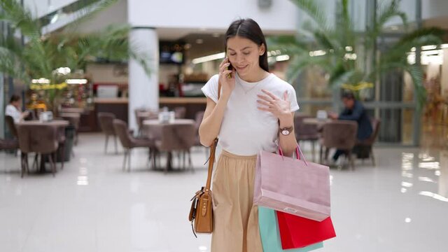 Female shopaholic bragging about her purchases in mall during seasonal sales