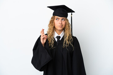 Young university graduate isolated on white background with fingers crossing and wishing the best