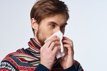 emotional man wiping his nose with a handkerchief infection virus light background