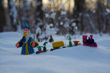 Figure of a wizard in the winter forest. Next to the Christmas toy train.