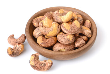 roasted cashew nuts with peel in the wooden plate, isolated on the white background