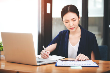 Asian woman working through laptop. business woman busy working with laptop computer at office