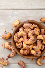 roasted cashew nuts in the wooden bowl on the table, top view