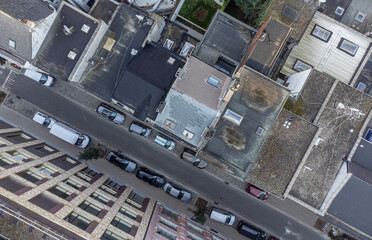 Top down drone shot of a street and top of buildings and roofs