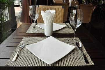 Empty plate spoon and fork on table.