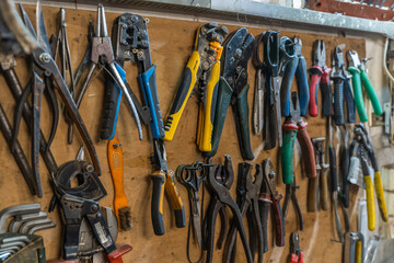 Set of pliers and nippers tools hanging on a wall