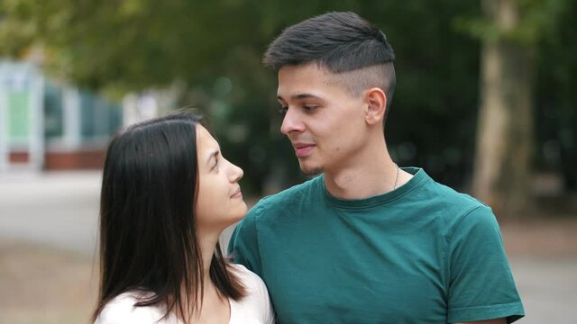 Smiling young couple standing, playing and talking to each other in summer 