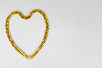 Heart-shaped gold necklace with copy space.
