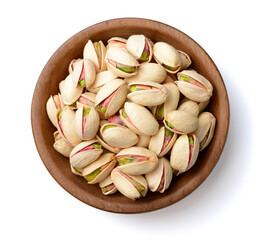 pistachios nuts in the wooden plate, isolated on white, top view