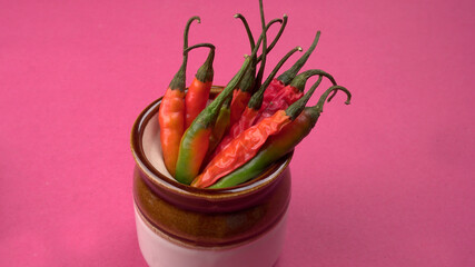 Fresh long Indian green and red chillies on wooden background.