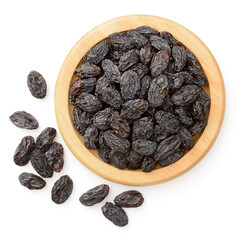 black raisins in the wooden bowl, isolated on white background, top view