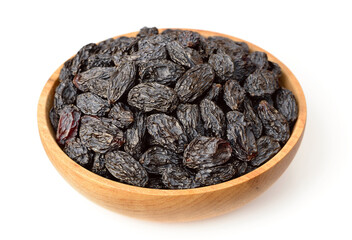 black raisins in the wooden bowl, isolated on white background