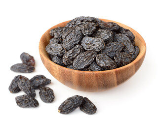 black raisins in the wooden bowl, isolated on white background