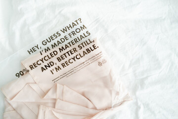 shirt in plastic bag with tag recycled materials and recyclable. zero waste concept.