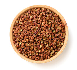 dried Szechuan pepper in the wooden plate, isolated on the white background, top view