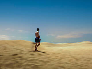 Hombre caminando por dunas en movimiento, islas canarias