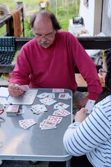 Father and daughter playing cards on a house porch