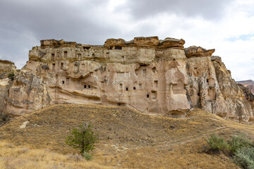 Fototapeta na wymiar Cappadocia, Turkey - September 1, 2021 – Impressive ancient cave home which had been carved in the Vulcanic rock cliff face of Pigeon Valley at Uchisar in the Cappadocia region of Turkey.
