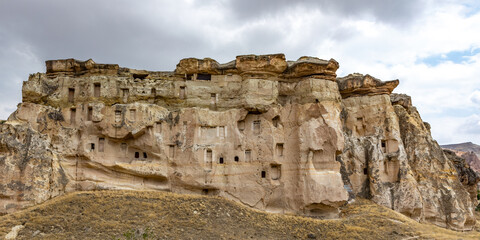 Fototapeta premium Cappadocia, Turkey - September 1, 2021 – Impressive ancient cave home which had been carved in the Vulcanic rock cliff face of Pigeon Valley at Uchisar in the Cappadocia region of Turkey.
