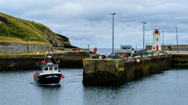 Fishing boat sailing into Lybster harbour in the Highlands
