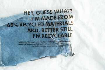 blue jeans in plastic bag with tag recycled materials and recyclable. zero waste concept.