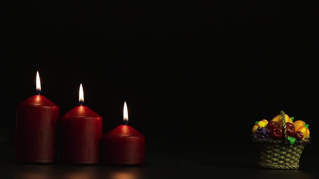Three burning candles and a basket of pumpkins, a horror story for Halloween. Isolated image on black background, copy space. Video, footage or background for splash screen, credits, cutouts, intro. 