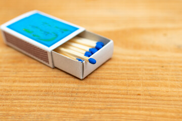 Matches in box on wooden background. Closeup shot. Matchsticks in open match-box flat lay.Matches in open match-box on a carton underlay.Selective focus.Copy space.